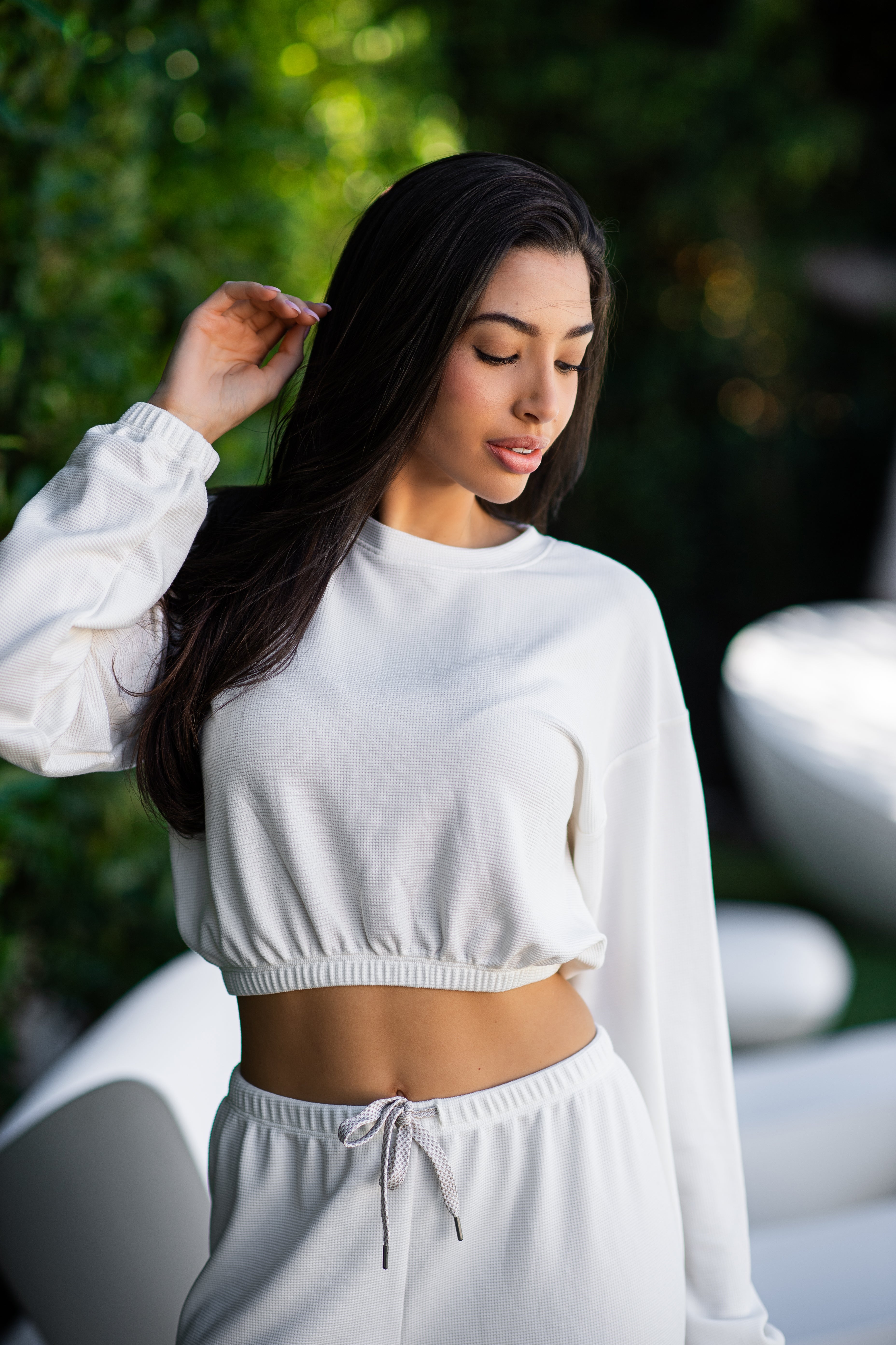 Caroline elasticized waist crop top with long sleeves and thumbholes in coconut cream, modeled with the Delaney joggers close front view