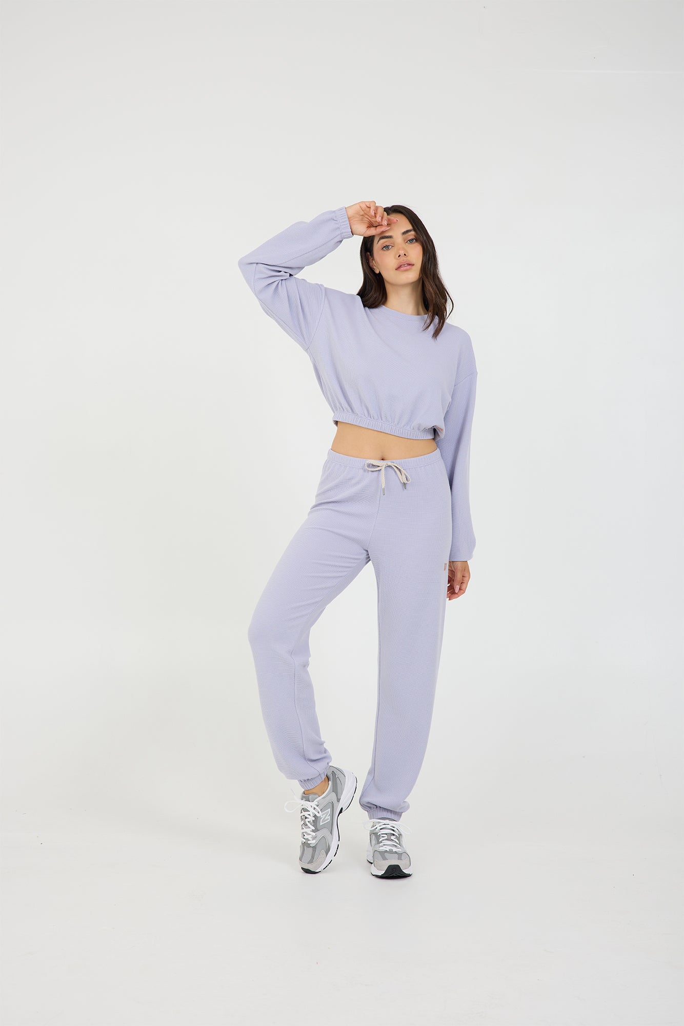 Caroline elasticized waist crop top with long sleeves and thumbholes in light amethyst, modeled with the Delaney joggers from the front 