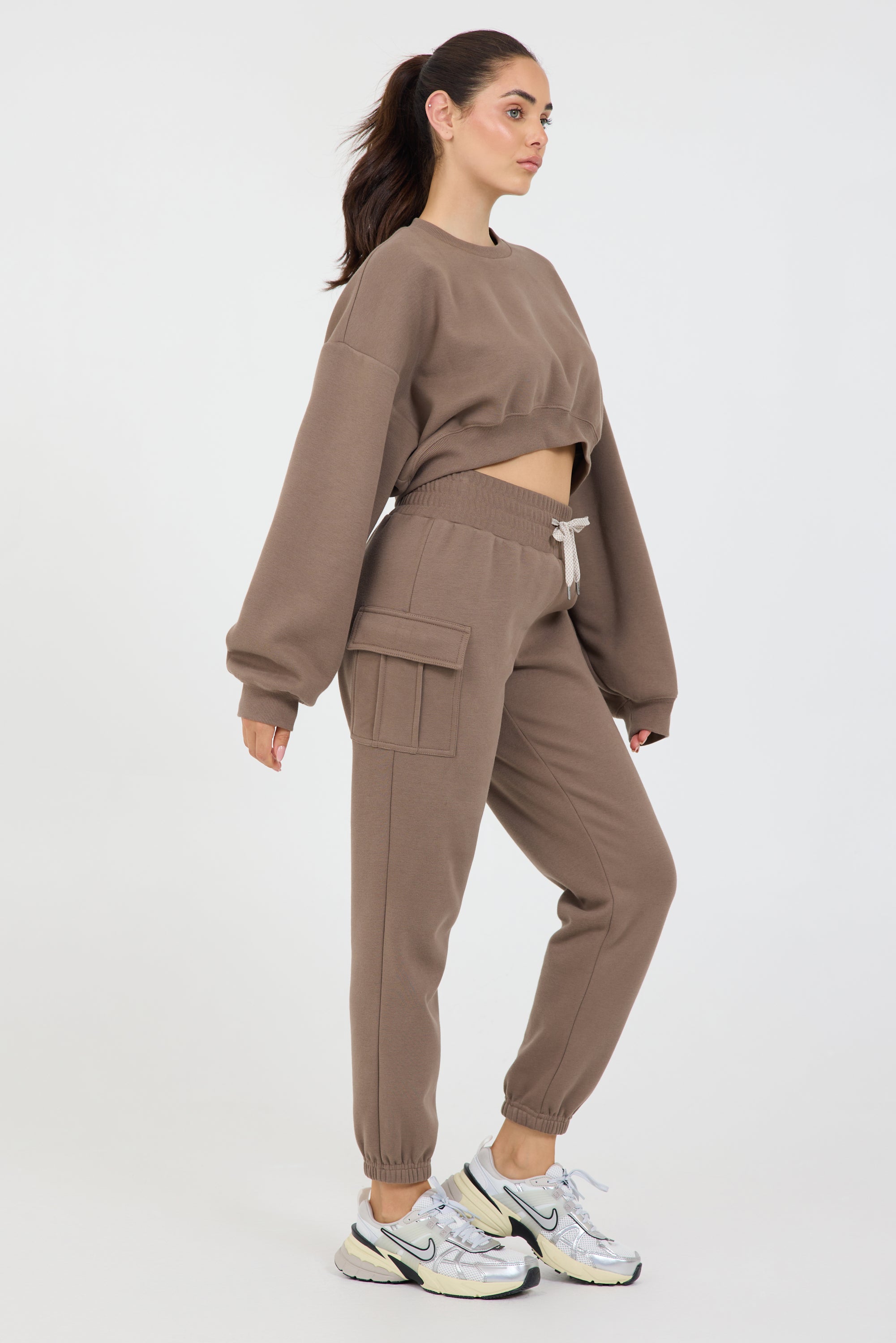 Claire fleece cropped long sleeve in dark truffle, modeled with the Kim Fleece cargo joggers from the side