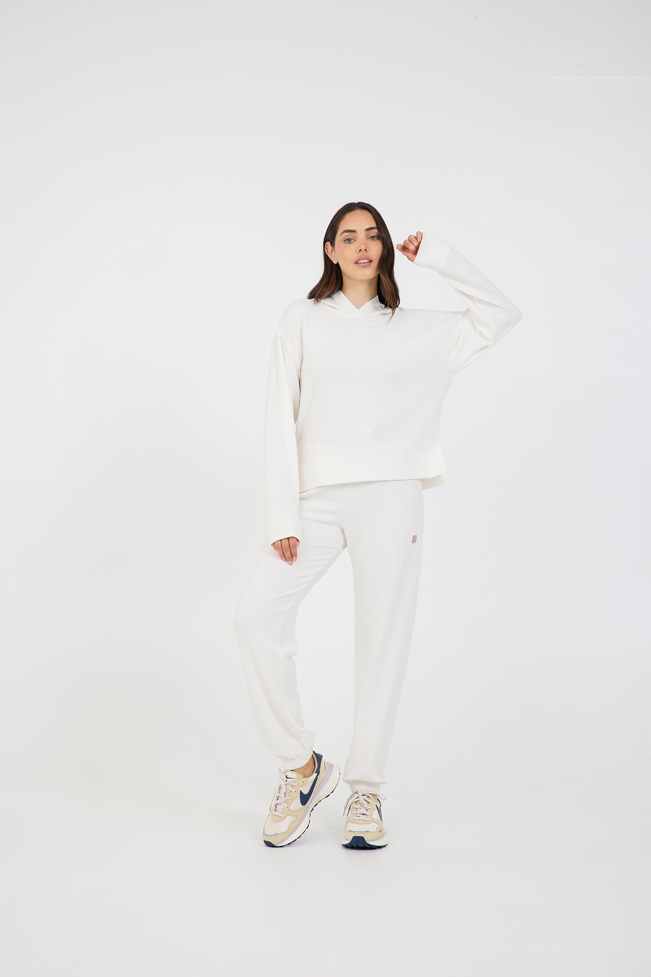 Delaney joggers in coconut cream, modeled with the Lynn pullover hoodie  with long sleeves and thumbholes from the front