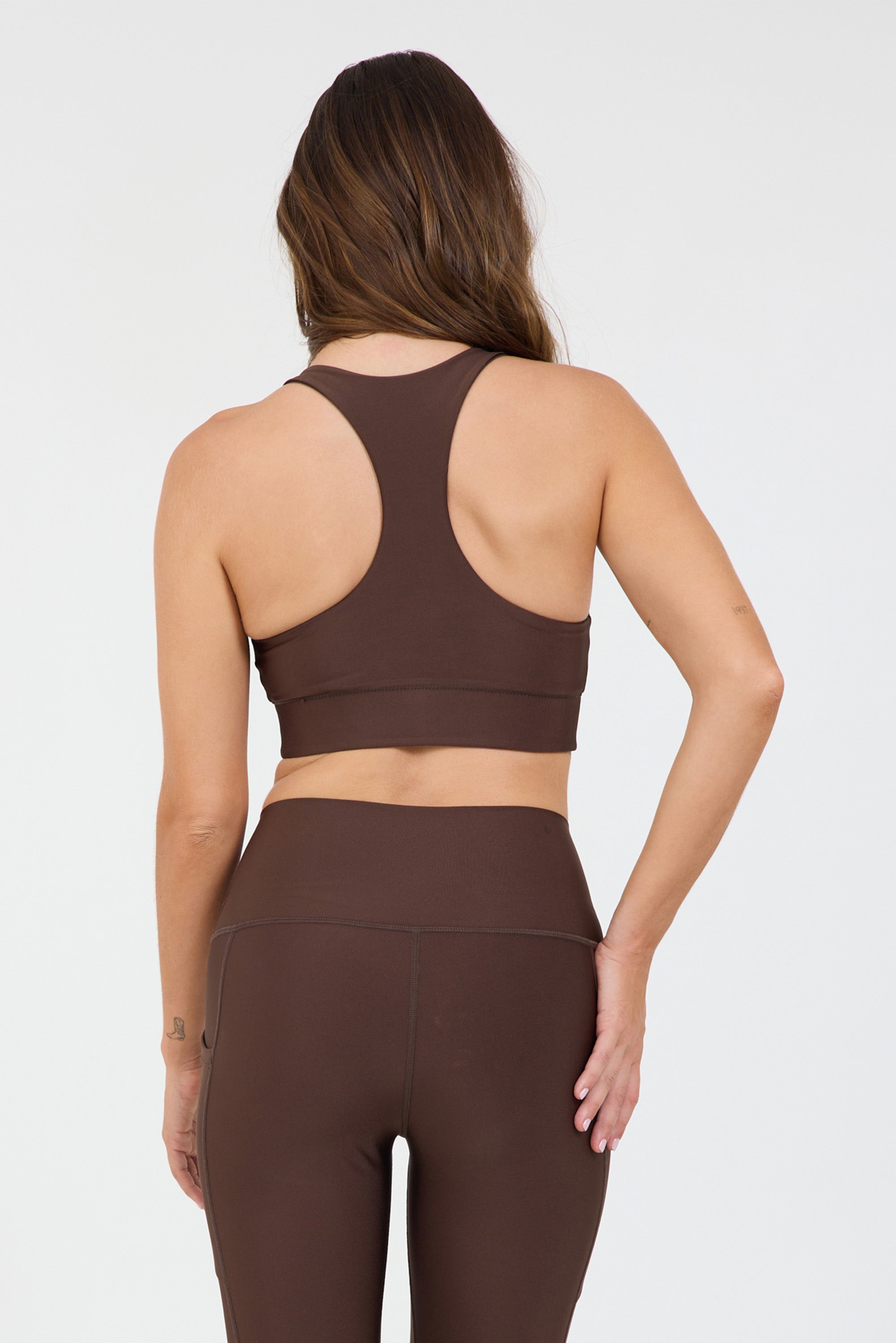 Joey bra in dark truffle, modeled with the Robby 7/8 leggings from the back
