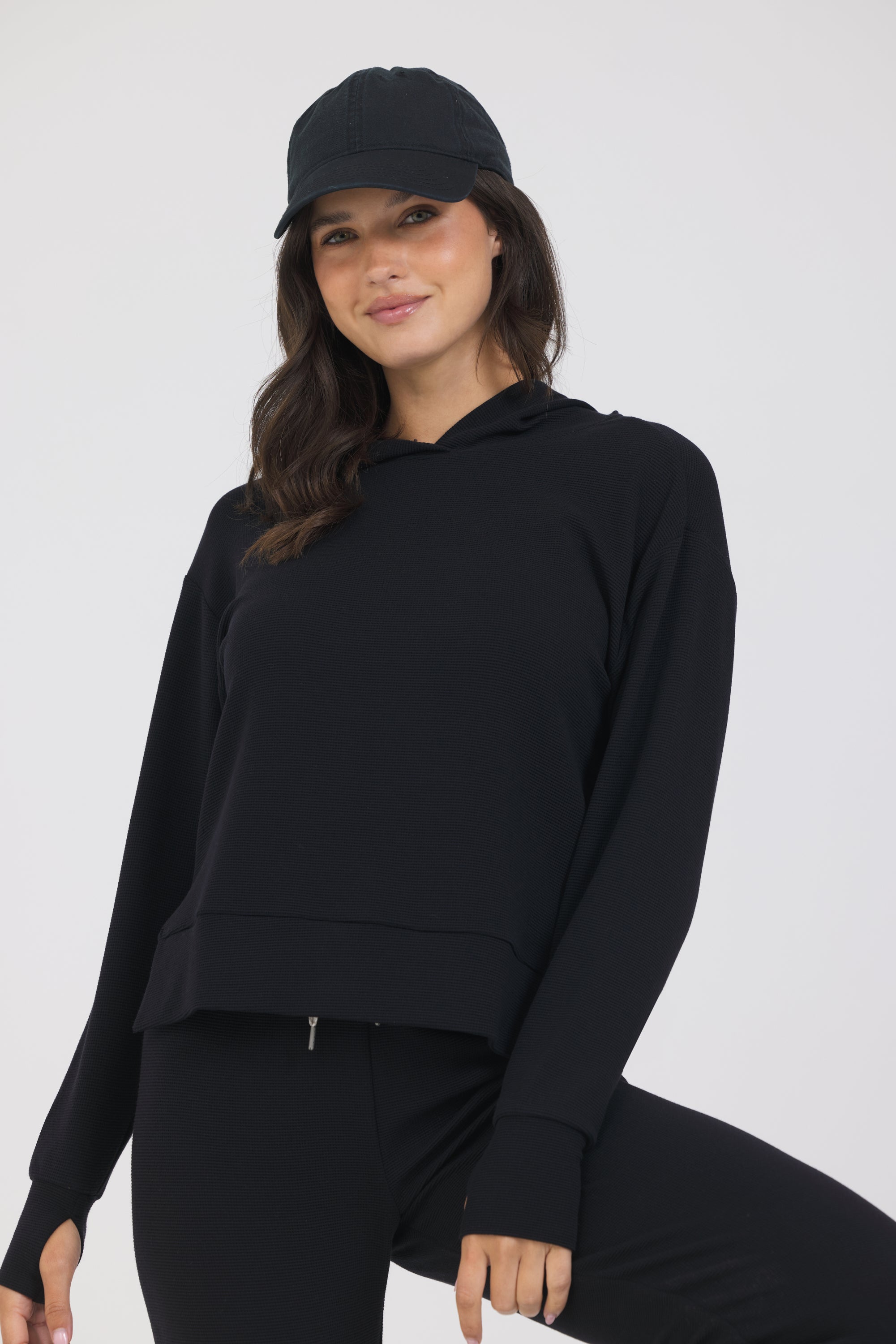 Lynn pullover hoodie with long sleeves in black, modeled with the Delaney joggers from the front